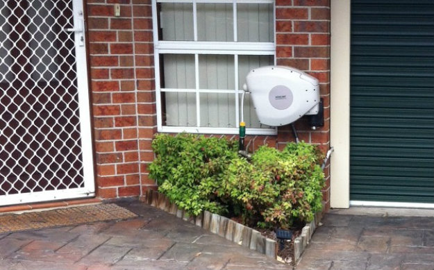 Hoselink Retractable reel mounted at the front of a house by the front door.