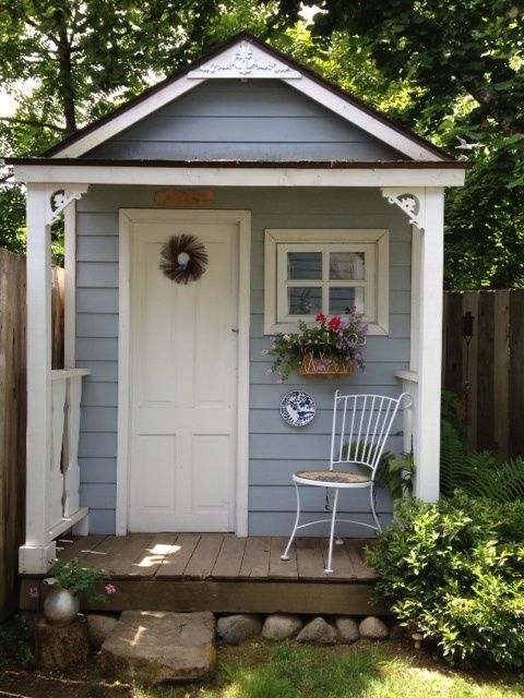 Simple blue shed with verandah and chair