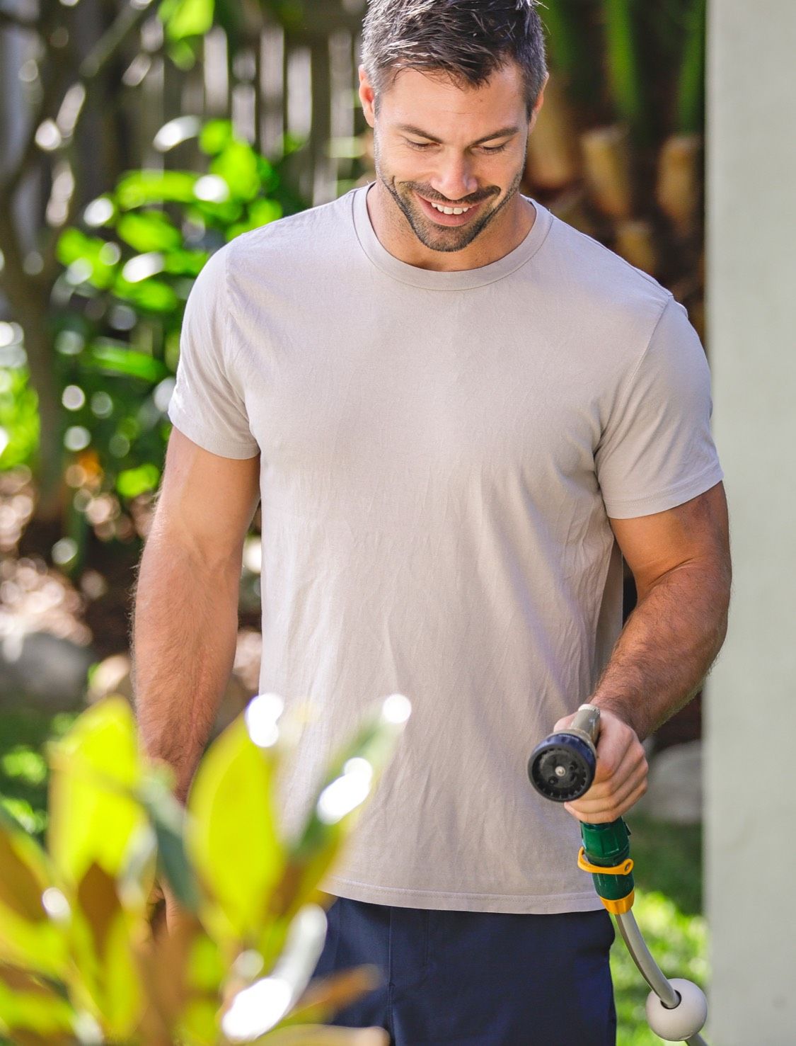 Man Watering Garden with Hose Reel